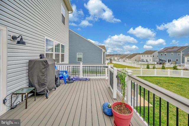 wooden deck with area for grilling and a yard