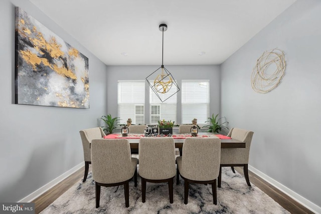 dining area featuring hardwood / wood-style flooring and an inviting chandelier