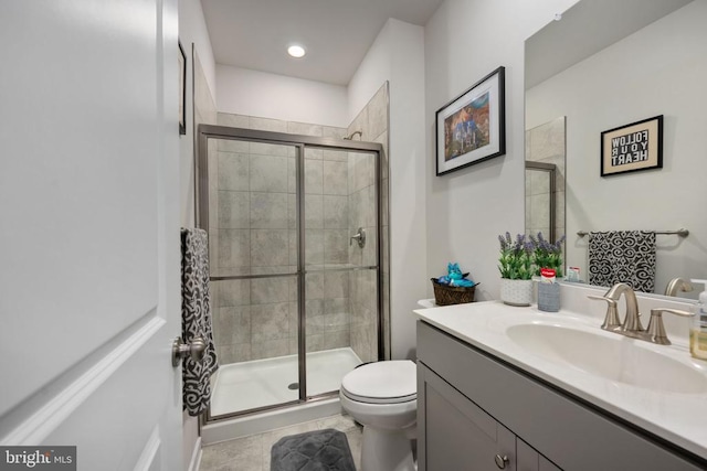 bathroom featuring tile patterned flooring, vanity, toilet, and a shower with shower door