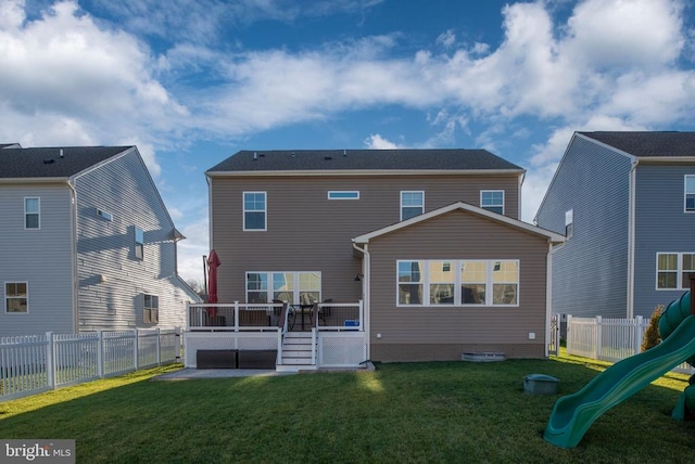 rear view of property featuring a playground and a lawn