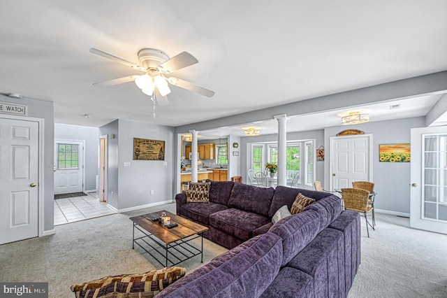 carpeted living room featuring ornate columns, ceiling fan, and a healthy amount of sunlight