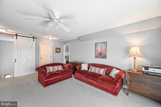 carpeted living room featuring a barn door and ceiling fan