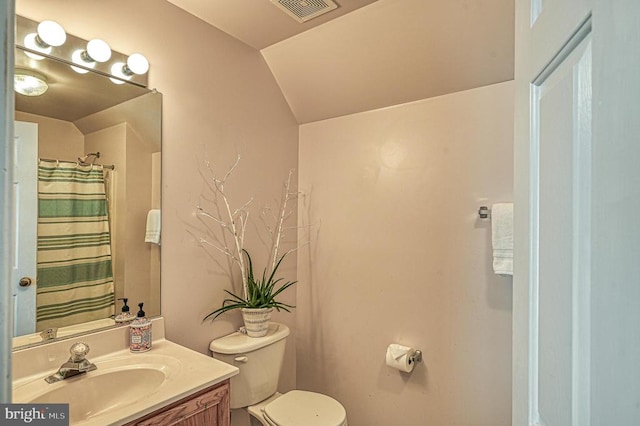 bathroom featuring vanity, toilet, walk in shower, and vaulted ceiling