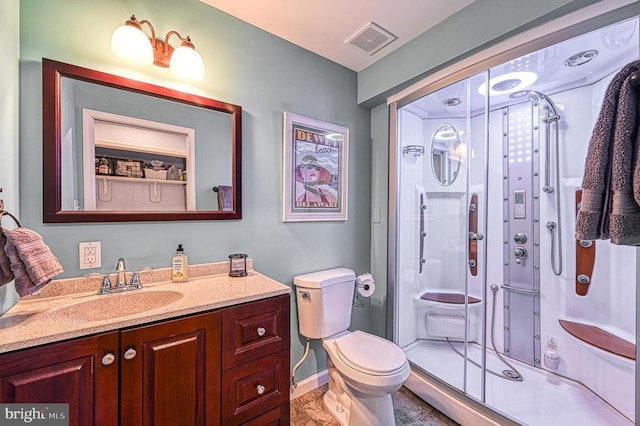 bathroom featuring vanity, toilet, and an enclosed shower