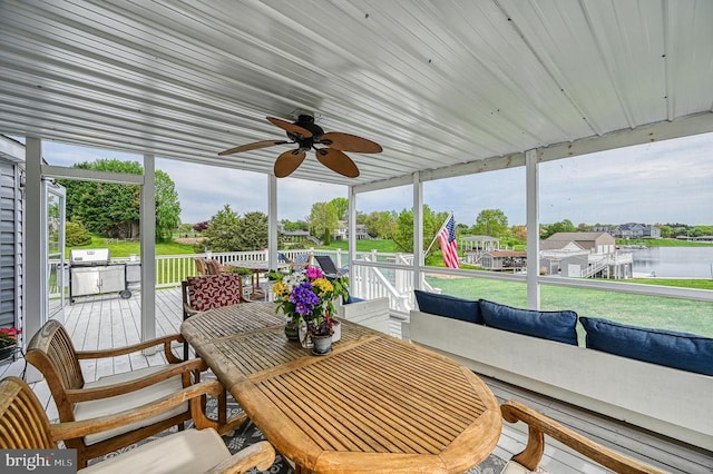 sunroom / solarium featuring a water view, a wealth of natural light, and ceiling fan