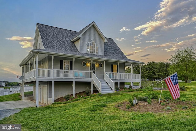 view of front of house with a porch, a yard, and a garage