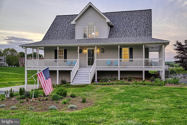 view of front of property with covered porch and a yard