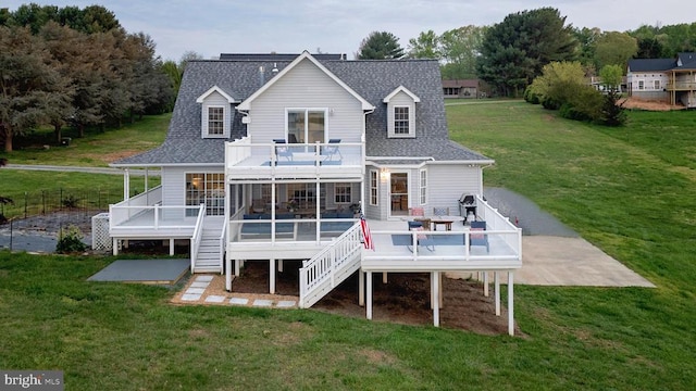 rear view of house with a patio area, a yard, and a wooden deck