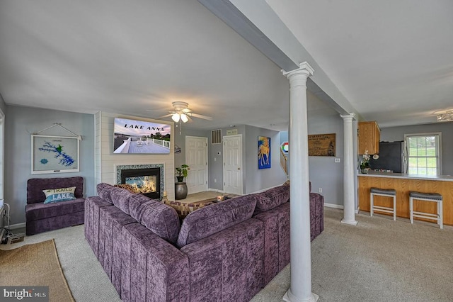 living room with light colored carpet, ceiling fan, and decorative columns