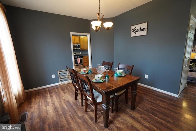 dining space featuring dark hardwood / wood-style floors and an inviting chandelier