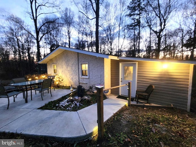 back house at dusk with a patio area