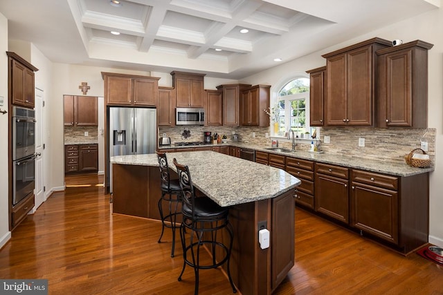 kitchen featuring decorative backsplash, appliances with stainless steel finishes, a center island, and beamed ceiling