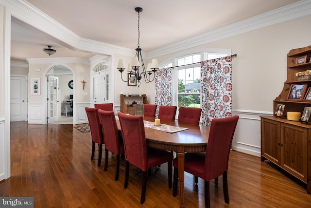 dining room featuring crown molding, dark wood-type flooring, and a notable chandelier