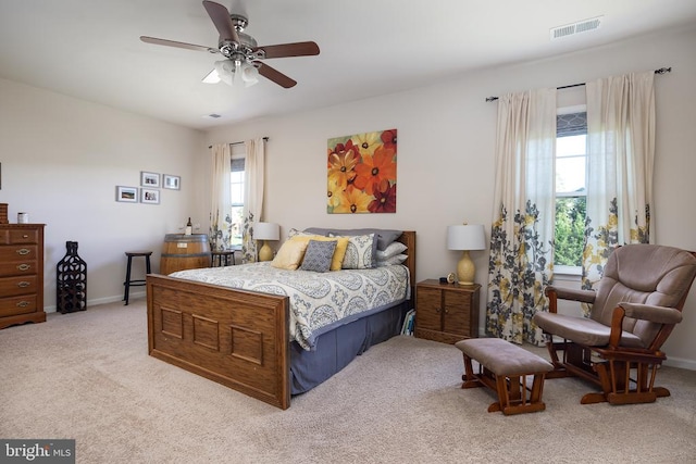 carpeted bedroom with ceiling fan and multiple windows