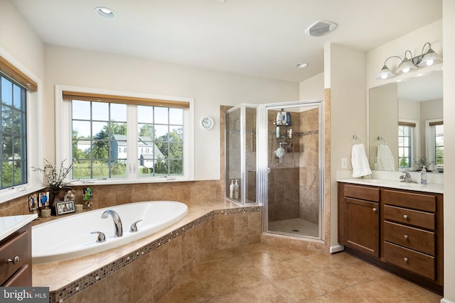 bathroom featuring plus walk in shower, vanity, and tile patterned flooring