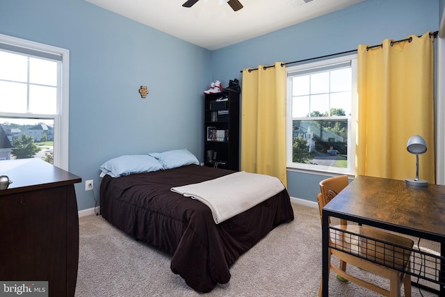 carpeted bedroom with multiple windows and ceiling fan