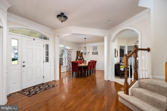 foyer entrance with hardwood / wood-style floors and crown molding