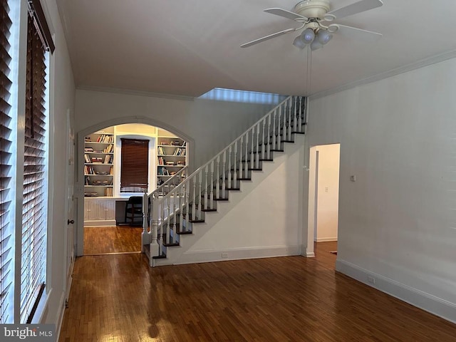 interior space with ceiling fan, dark hardwood / wood-style flooring, ornamental molding, and a wealth of natural light