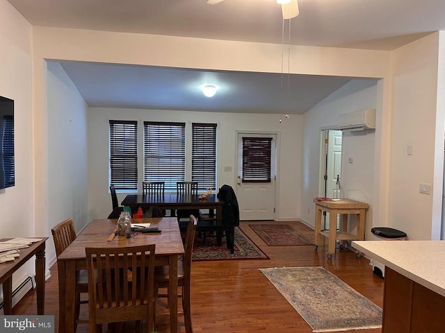 dining space featuring a wall unit AC and dark hardwood / wood-style flooring