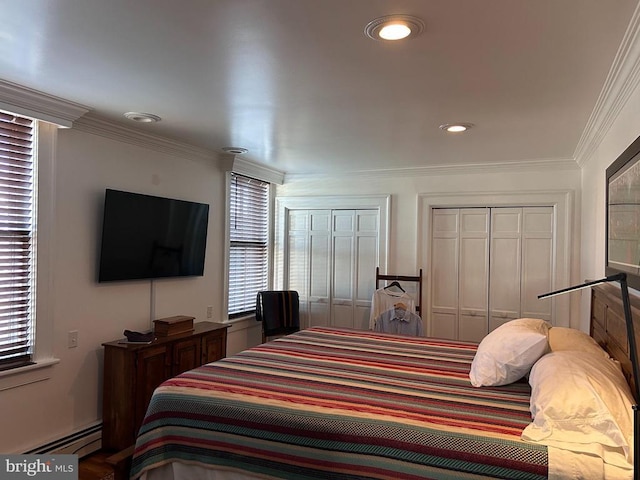 bedroom featuring multiple closets, ornamental molding, and a baseboard heating unit