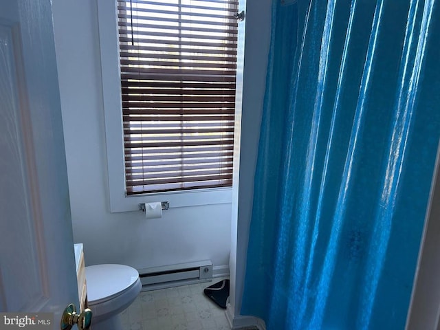 bathroom featuring plenty of natural light, toilet, and a baseboard heating unit