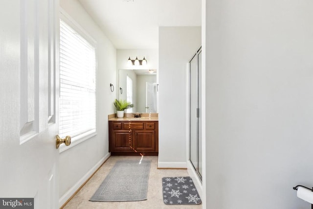 bathroom featuring vanity, a wealth of natural light, and walk in shower