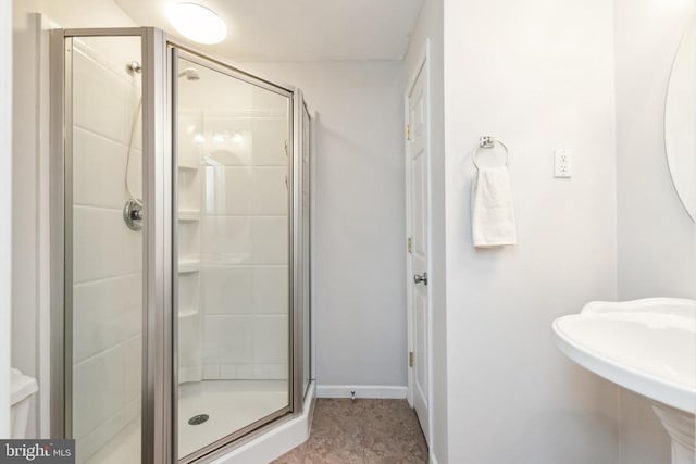 bathroom with sink and a shower with door