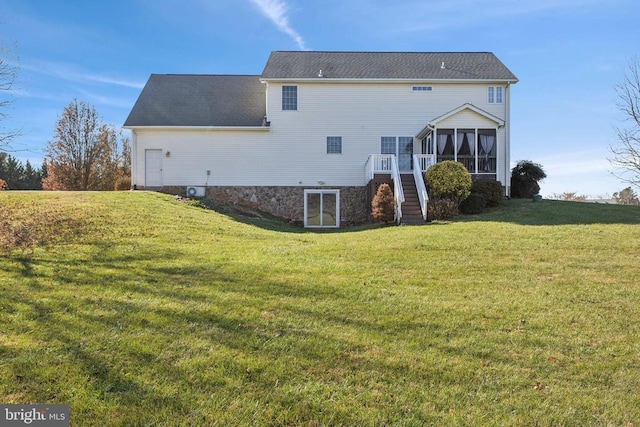 rear view of house with a sunroom and a yard