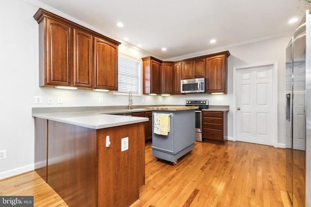 kitchen featuring sink, crown molding, a center island, light wood-type flooring, and stainless steel appliances