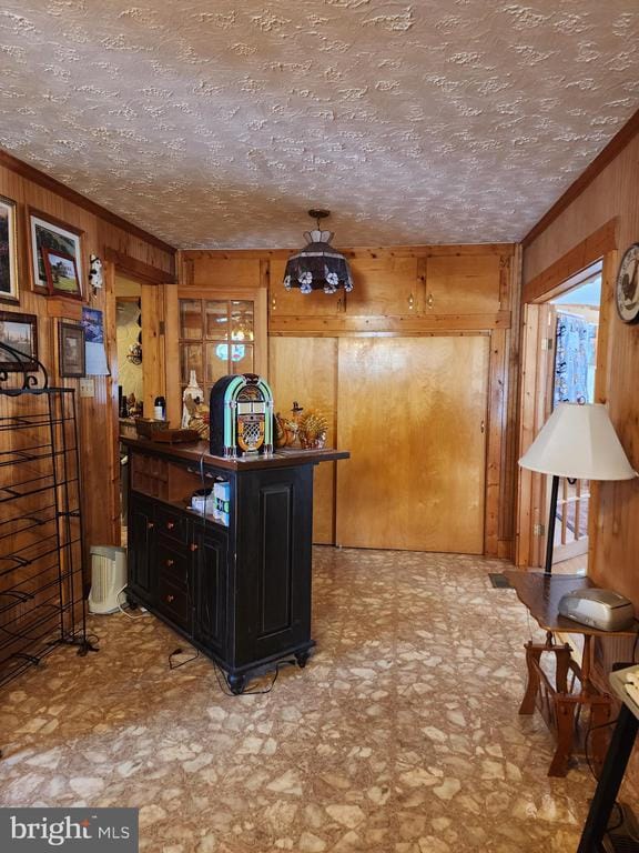 bar featuring ornamental molding and wood walls