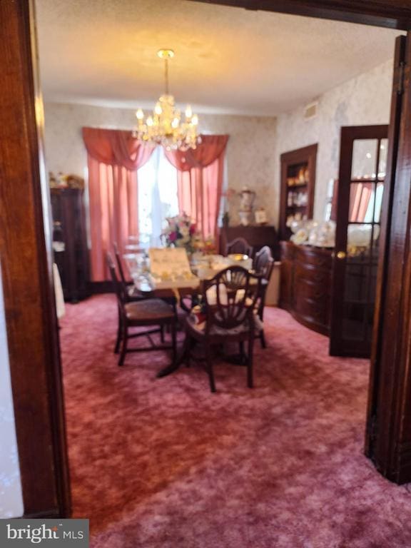 dining area with carpet flooring and a notable chandelier