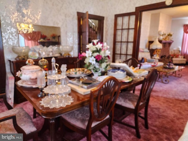 dining space with carpet floors and a chandelier