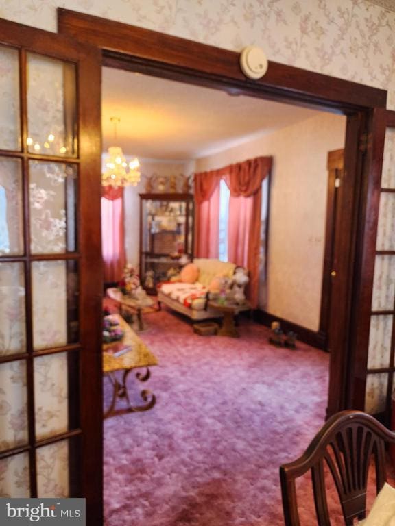 carpeted living room with an inviting chandelier