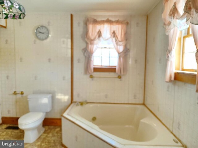 bathroom with toilet and a tub