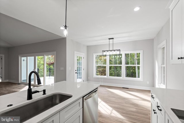 kitchen with dishwasher, sink, white cabinets, and light wood-type flooring