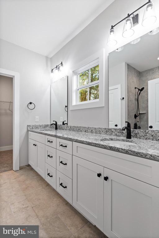 bathroom featuring a tile shower and vanity