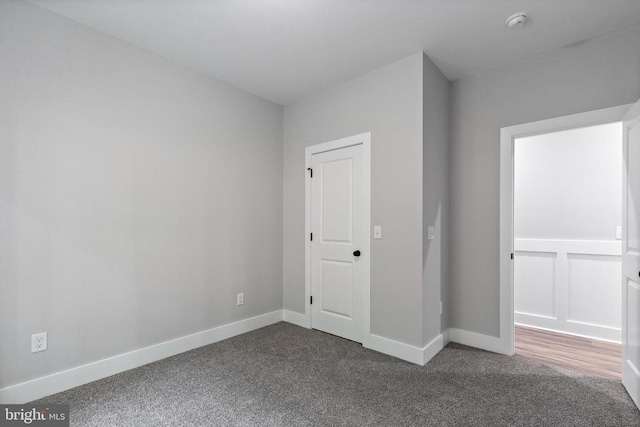 unfurnished bedroom featuring dark carpet