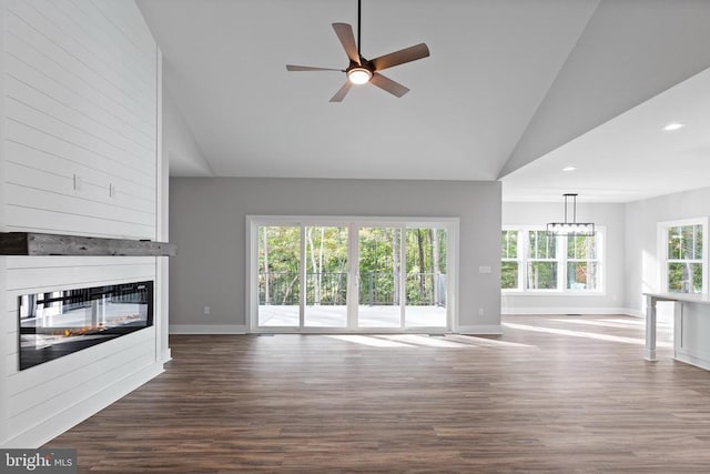 unfurnished living room featuring a fireplace, hardwood / wood-style floors, ceiling fan with notable chandelier, and high vaulted ceiling