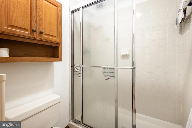 bathroom with toilet and a shower with shower door