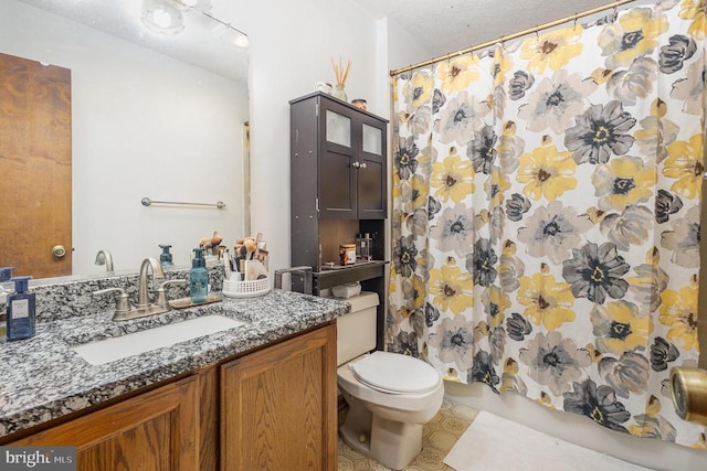 bathroom with a textured ceiling, vanity, toilet, and walk in shower