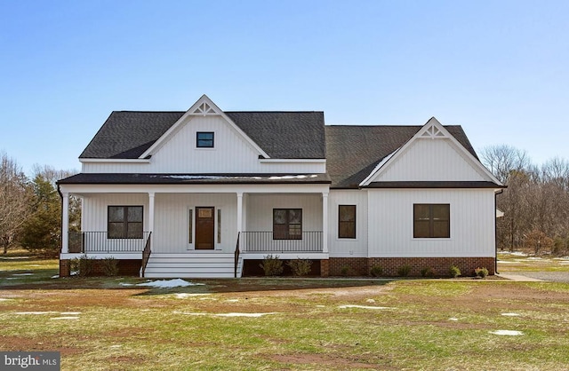 modern inspired farmhouse featuring a porch and a front yard