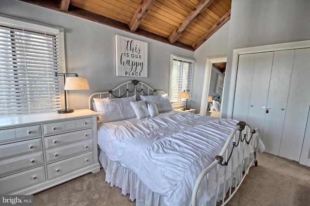 bedroom with vaulted ceiling with beams, a closet, light colored carpet, and wooden ceiling