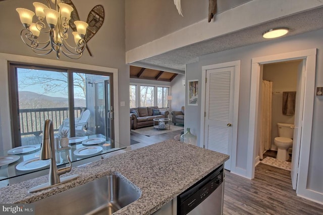 kitchen featuring hardwood / wood-style flooring, a mountain view, dishwasher, and sink