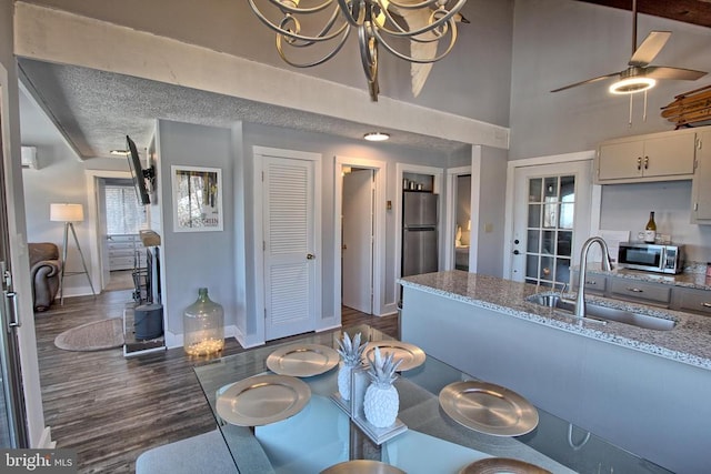 dining area with a wall mounted air conditioner, ceiling fan with notable chandelier, sink, dark hardwood / wood-style floors, and a textured ceiling