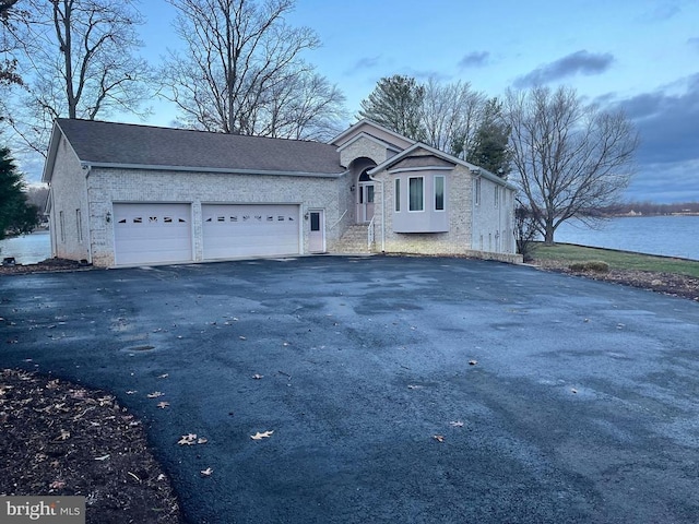 front of property featuring a garage and a water view