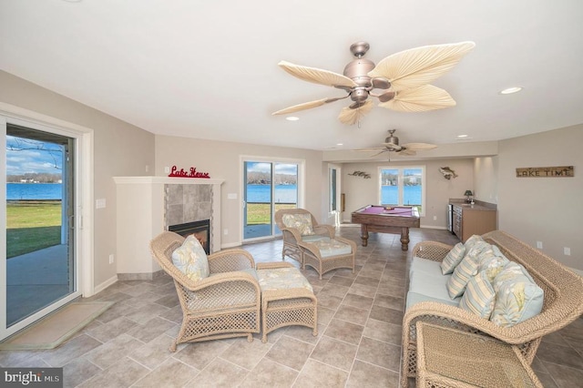 living room with ceiling fan, a fireplace, and billiards