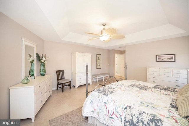 bedroom with a raised ceiling and ceiling fan