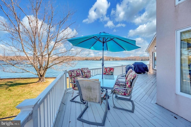 wooden terrace with area for grilling and a water view