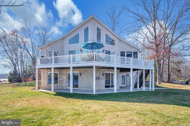 back of property with a lawn, a patio area, and a deck