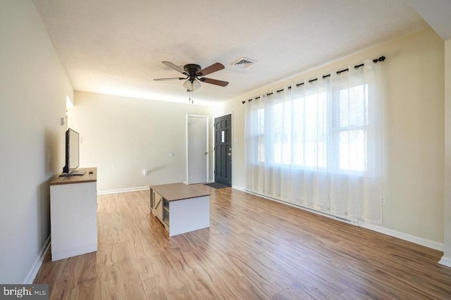 unfurnished living room featuring light wood-type flooring and ceiling fan